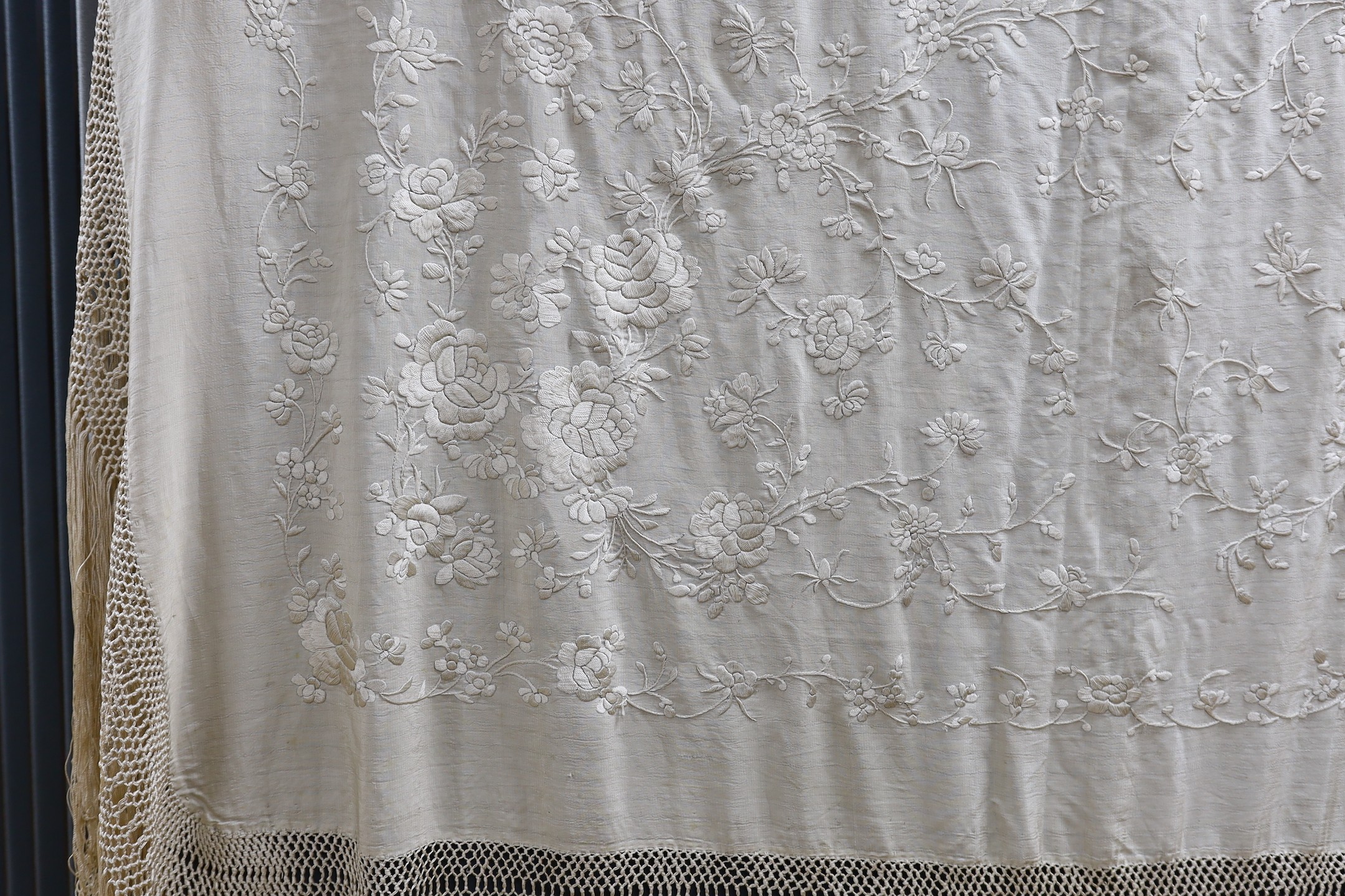 A Chinese late 19th century silk embroidered shawl, with cream on cream embroidery and a cream silk fringe, 140x134 cms